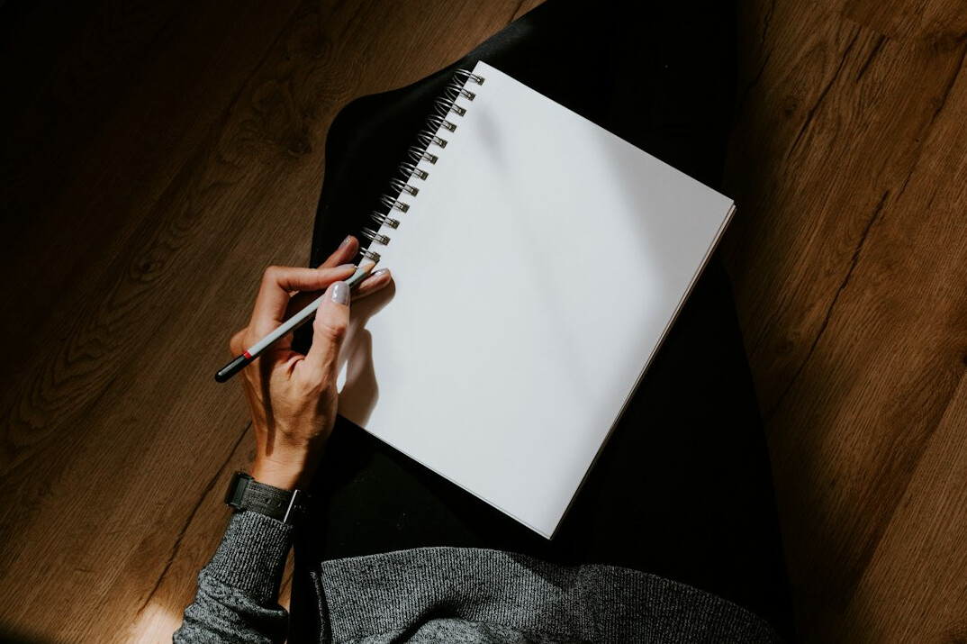 person writing goals in notebook